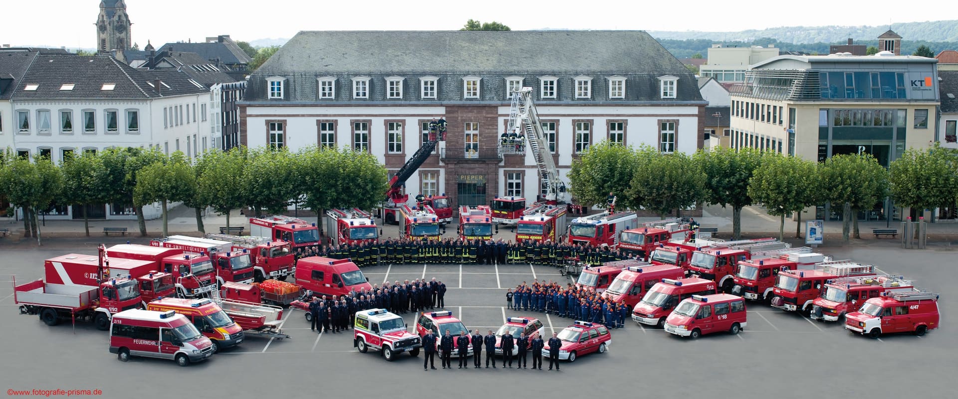 Die Freiwillige Feuerwehr Saarlouis mit allen Fahrzeugen und Mannschaften im Halbkreis vor dem Rathaus auf dem Großen Markt